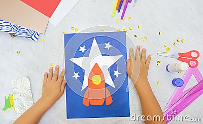 Child making rocket and stars from paper. Creative children play with craft. The space theme development of children. School Stock Photo