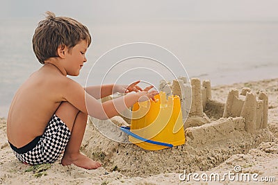 Child making sand castles at the beach Stock Photo