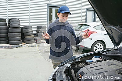 A child mechanic changes fuses in a car. Repair services in car service. Auto repair concept Stock Photo
