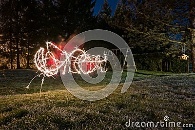 Child and mother light painitng with christmas sparklers outside. Stock Photo