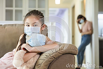 Child and mother in medical masks while coronavirus quarantined at home Stock Photo