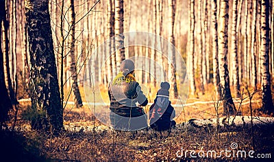 Child and mother sitting on birch tree trunk in forest. Editorial Stock Photo