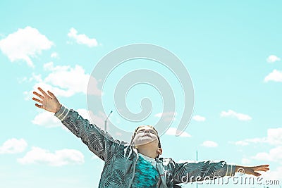 Child with open arms looking up at the sky Stock Photo