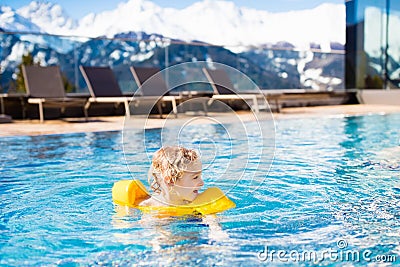 Child in outdoor swimming pool of alpine resort Stock Photo