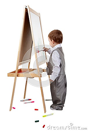 A child paints on an easel in the studio Stock Photo