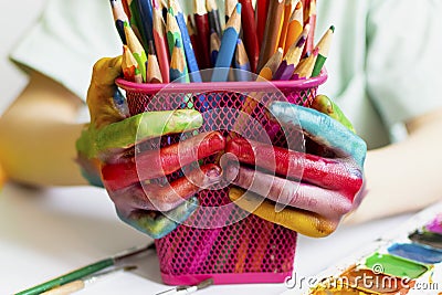 The child paints. Palms and hands of a child in multi-colored watercolor. Watercolor, gouache, paint brushes, colored Stock Photo