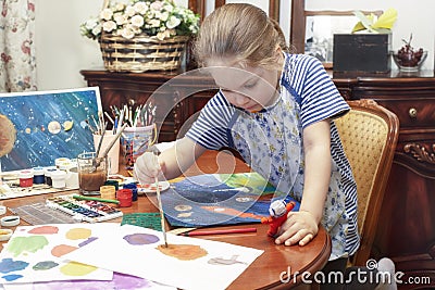 Preschool girl paints and makes papier mache crafts Stock Photo