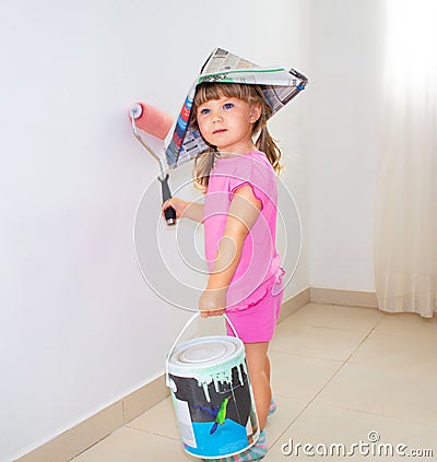 The child paints the wall with a roller Stock Photo