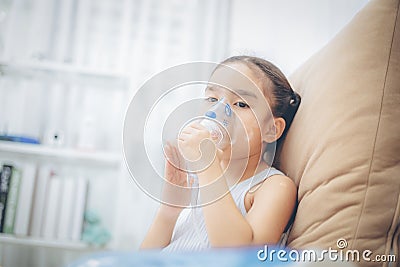 Child patient inhalation therapy by the mask of inhaler with soft stream smoke from bronchodilator. Stock Photo