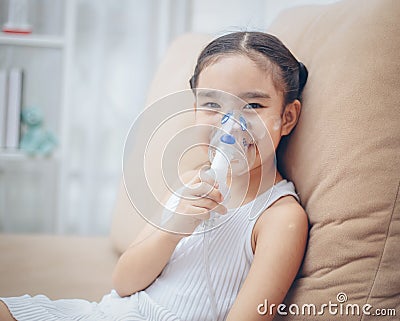 Child patient inhalation therapy by the mask of inhaler with soft stream smoke from bronchodilator. Stock Photo