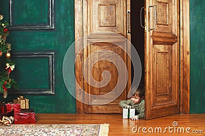 Child peeking from behind the door of the gift Stock Photo