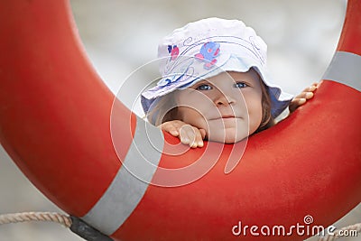 Child peeking out of the lifebuoy Stock Photo