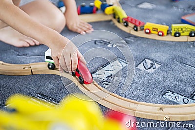 Child play with wooden train, build toy railroad at home or kindergarten. Toddler kid play with wooden train Stock Photo