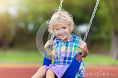 Child on playground. swing Kids play outdoor Stock Photo