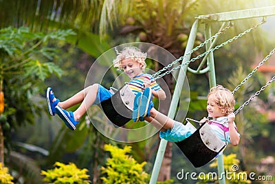 Child on playground. swing Kids play outdoor Stock Photo