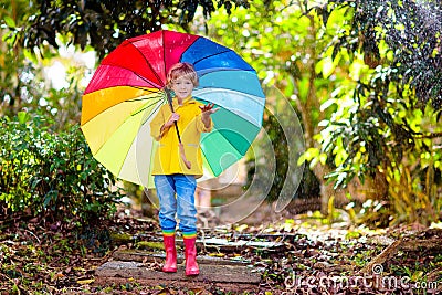 Child playing in autumn rain. Kid with umbrella Stock Photo