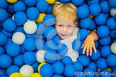 Child playing in ball pit. Colorful toys for kids. Kindergarten or preschool play room. Toddler kid at day care indoor Stock Photo