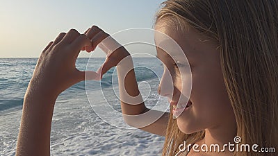 Child Playing on Beach, Kid Watching Sea Waves, Girl Makes Heart Shape Love Sign Stock Photo