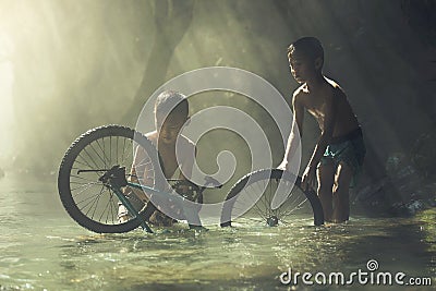 Child playing with bicycle in the creek Stock Photo