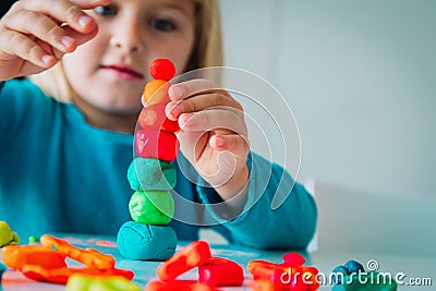 Little girl playing with clay molding shapes, kids crafts Stock Photo