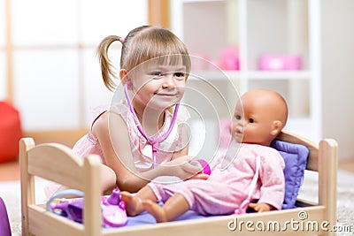 Child Playing Doctor with doll Toy Stock Photo