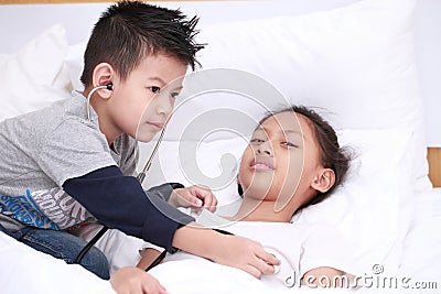 Child playing doctor or nurse with plush girl with bright on the Stock Photo
