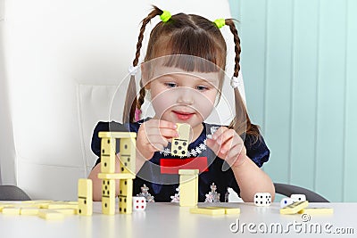 Child playing with dominoes at table Stock Photo