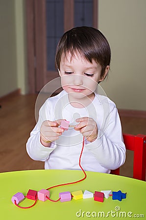 Child playing with educational toys beading Stock Photo