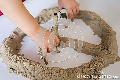 Child playing with kinetic sand. Baby`s sensory experiences Stock Photo