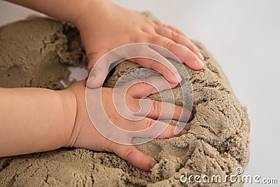 Child playing with kinetic sand. Baby`s sensory experiences Stock Photo