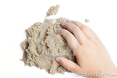Child playing with kinetic sand. Hand of the child in the sand c Stock Photo