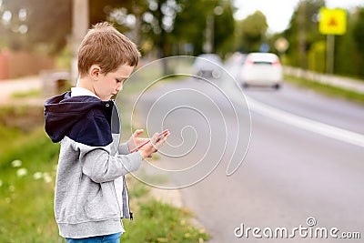 Child playing mobile games on smartphone on the street Stock Photo