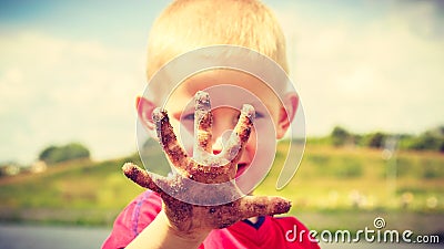 Child playing outdoor showing dirty muddy hands. Stock Photo