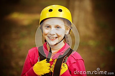 Child playing on the playground. Eco Resort Activities. Safe Climbing extreme sport with helmet. Toddler climbing in a Stock Photo