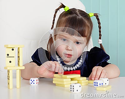 Child playing with small toys at table Stock Photo