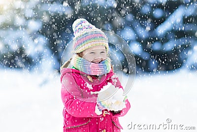 Child playing with snow in winter. Kids outdoors. Stock Photo