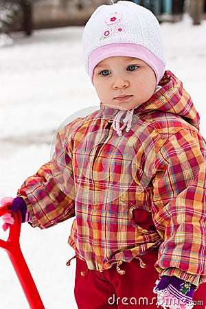 Child playing with spade in snow Stock Photo