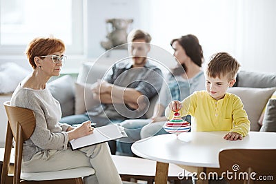 Child playing with spinning top ADHD therapy with parents Stock Photo