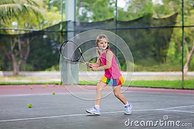 Child playing tennis on outdoor court Stock Photo