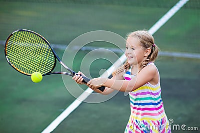 Child playing tennis on outdoor court Stock Photo