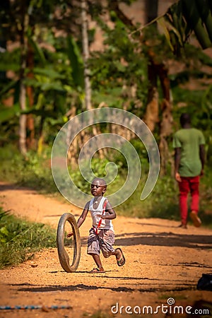 Child playing with a tire in Uganda. Editorial Stock Photo