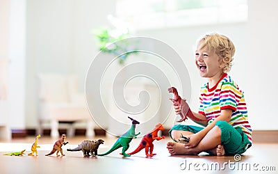 Child playing with toy dinosaurs. Kids toys Stock Photo