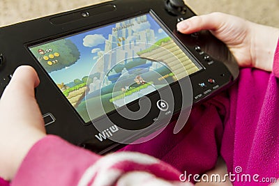Child playing the Wii U game Super Mario Bros Editorial Stock Photo