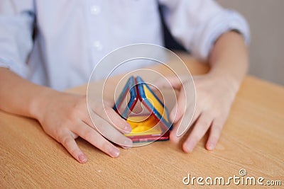 The child plays in the color designer on the table, builds a house, the concept of a family, the concept of building a new housing Stock Photo