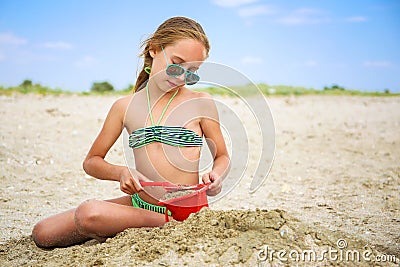 Child plays with sand on beach Stock Photo