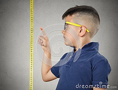 Child pointing at his height on measuring tape Stock Photo