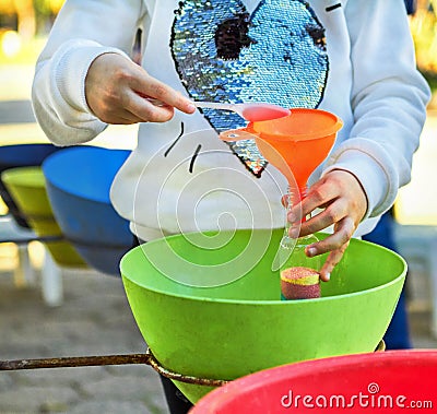 Child pour colored sand in the bottle Stock Photo