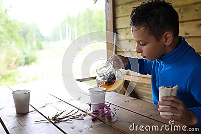 Child pouring herbal tea Stock Photo