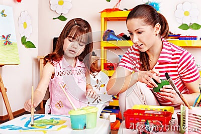 Child in preschool with teacher draw. Stock Photo