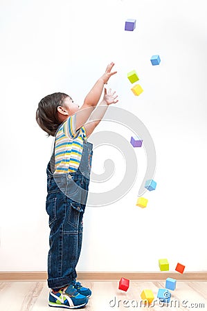 Child pulls hands upwards for toys Stock Photo